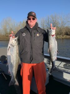 man holding two salmon